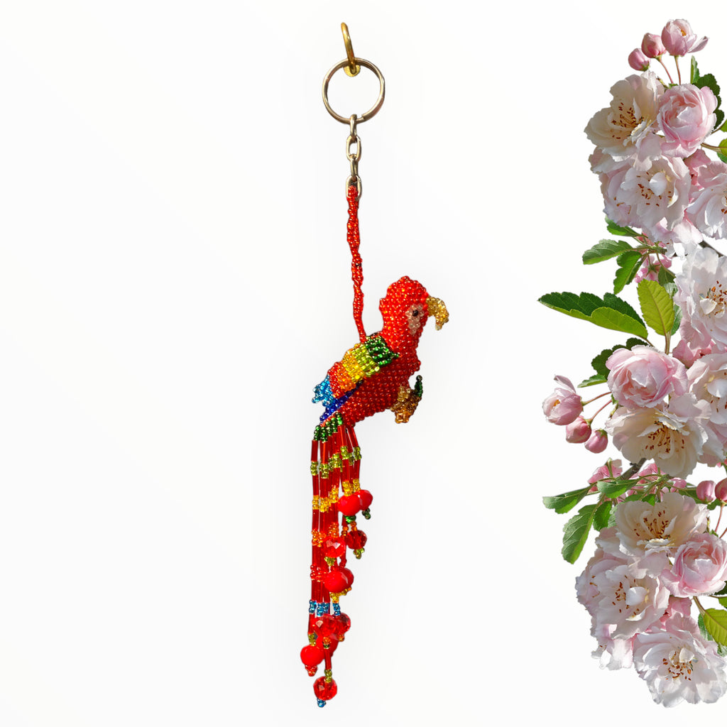 Elevate your style with our striking Red Beaded Parrot Keychain. This handcrafted masterpiece features a vivid red body adorned with a golden beak, multicolor wings that mimic nature's brilliance, and a cascading tail embellished with colorful beads. It's a captivating accessory that adds a burst of color and personality to your keys, bags, or car mirror.