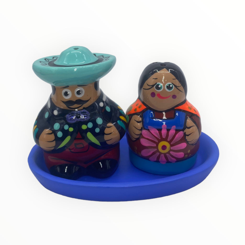 Experience the true essence of Mexican artistry with this handcrafted salt and pepper shaker duo. The mustached gentleman, dressed in a turquoise hat and a dapper blue jacket, complements the sweet-faced lady in her captivating red dress embellished with a subtle floral detail.